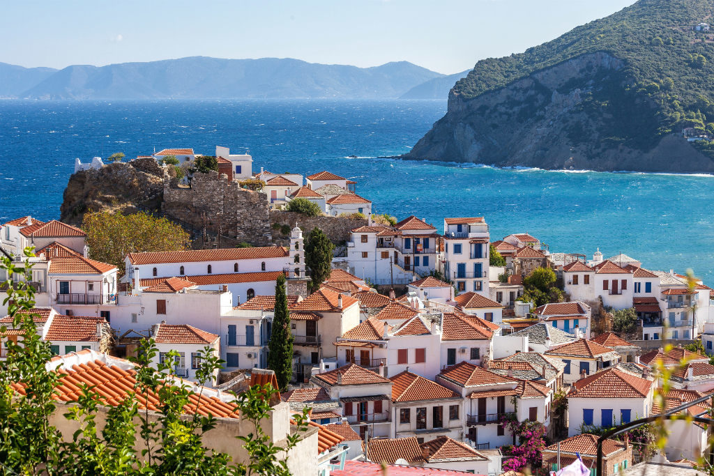 Skopelos Island, Greece — whitewashed town cascading down a hillside to the turquoise Aegean Sea